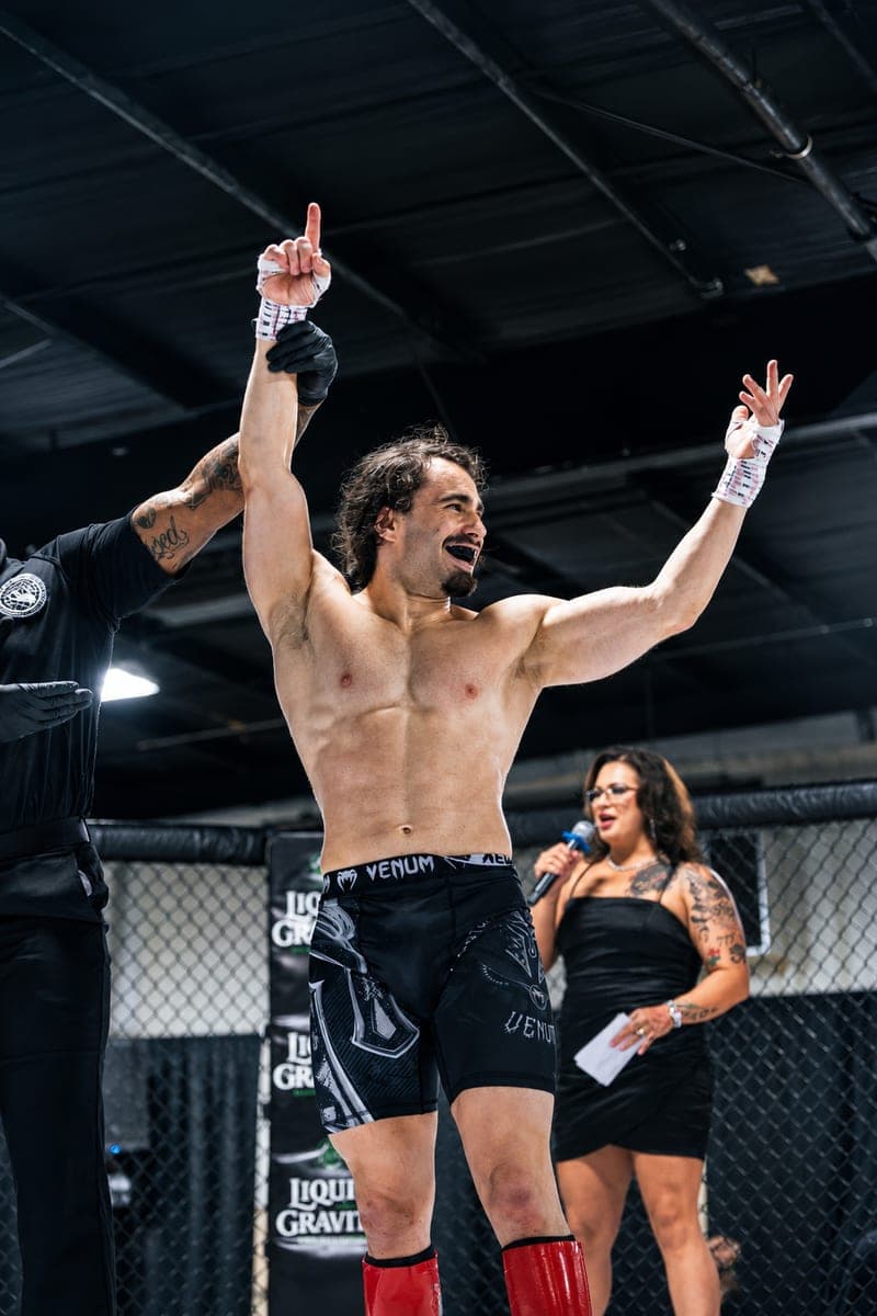 A mixed martial artist training inside the cage.